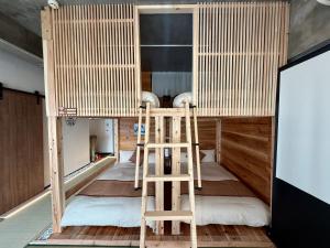 a bunk bed with two wooden ladders in a room at New Open Japanese style with large bath in Ukaji