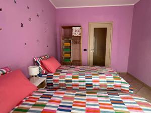 a bedroom with a bed and purple walls at Casa di Amalia 14 in Biella