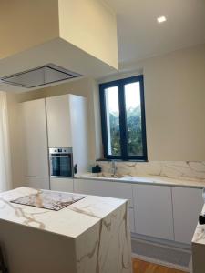 a kitchen with a white counter top and a window at VillaSu Event Experience in Missaglia