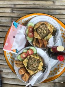 two plates of food on a wooden table at Eger Rise Terrace Bungalow in Kotaraja