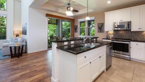 a kitchen with white cabinets and a counter top at SUMMER BREEZE Sunny 2BR Kulalani Home Next To Community Pool in Waikoloa