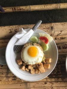 a plate of food with an egg and waffles at Lha Terrace Bungalow in Kotaraja +85 photos