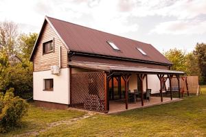 a large white house with a black roof at Wróbelek in Białowieża