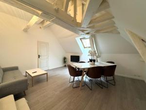 a living room with a table and chairs and a couch at Le Duplex de Villeneuve in Villeneuve-sur-Yonne
