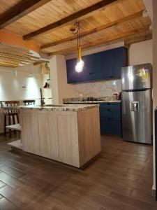 a kitchen with blue cabinets and a stainless steel refrigerator at Cactus Living in Duitama