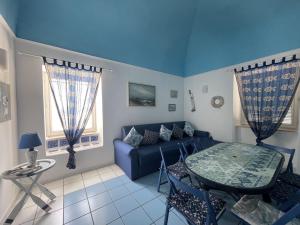 un soggiorno con un divano blu e un tavolo di Turistcasa - Il Pizzicato a Ponza