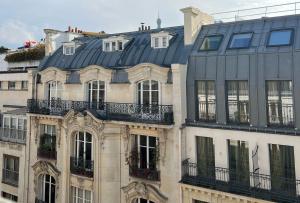 um edifício com um telhado preto e janelas em Room in apartment with view of the Eiffel Tower em Paris
