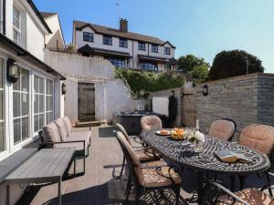 een terras met een tafel en stoelen en een barbecue bij Rosebank Cottage in Woolacombe