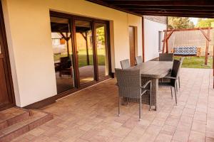 a patio with a wooden table and chairs at Wróbelek in Białowieża