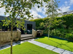 a garden with green grass and a wooden fence at Uno Moor Side - 4 Bed, 2 Bath, Garden, sleeps 8 - Parking in Carbis Bay