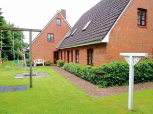 a red brick building with a basketball hoop in the yard at Gaestehaus-Bruhn-6 in Alkersum