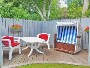 a deck with two chairs and a table and a table and chairs at Gaestehaus-Bruhn-6 in Alkersum