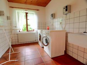 a laundry room with a washing machine and a sink at Gaestehaus-Bruhn-6 in Alkersum