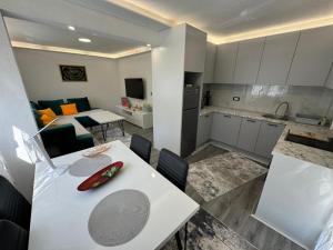 a kitchen and living room with a white table and chairs at Vila Vacation Sarajevo in Hadžići