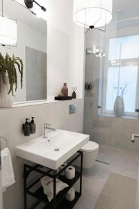 ベルリンにあるDesign Apartment with Gardenの白い洗面台とトイレのあるバスルーム