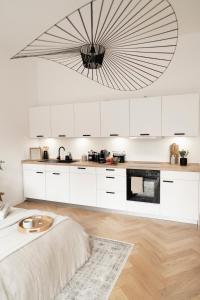 ベルリンにあるDesign Apartment with Gardenの白いキャビネットと大きなシャンデリア付きのキッチン