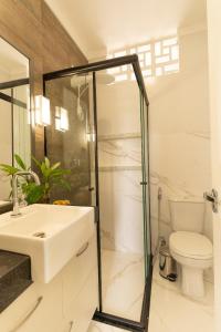 a bathroom with a shower and a sink and a toilet at Apartamento aconchegante e moderno na melhor área da cidade, Cozy and modern apartment in best area of the city in Belém