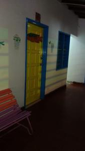Una puerta amarilla y azul en una habitación con un banco. en Hotel vista mar, en Santa Marta