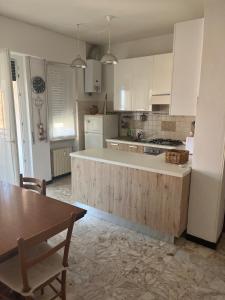 a kitchen with white cabinets and a wooden counter top at Casa di Rita - Appartamento nel centro di Riva Trigoso vicino alla spiaggia in Riva Trigoso +8 photos
