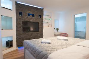 a bedroom with a large bed and a brick wall at Time4you am Bodensee mit Pool Sauna Kamin in Radolfzell am Bodensee +19 photos