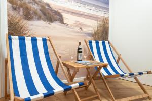 two chairs and a table with a bottle of wine at Time4you am Bodensee mit Pool Sauna Kamin in Radolfzell am Bodensee