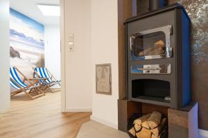 a fireplace with a tv in a room with chairs at Time4you am Bodensee mit Pool Sauna Kamin in Radolfzell am Bodensee