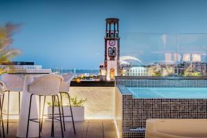 a balcony with a clock tower and a swimming pool at AC Hotel by Marriott Tenerife in Santa Cruz de Tenerife