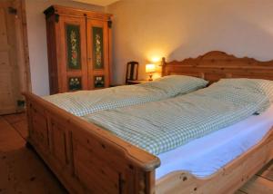ein großes Bett in einem Schlafzimmer mit einem Holzrahmen in der Unterkunft Schwarzwaldbauernhaus Bernau in Bernau im Schwarzwald