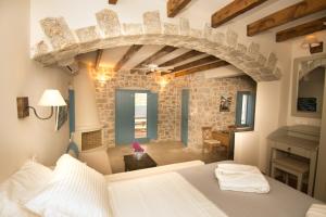 a bedroom with a bed and a stone wall at Petra Boutique Homes in Aryinónda +100 photos