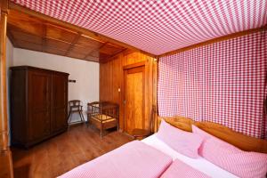 a bedroom with a bed and a red and white checked wall at Schwarzwaldbauernhaus Wutach in Lembach