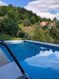 a swimming pool with a view of a house at Casa das Fragas in Celorico de Basto
