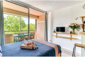a bedroom with a bed with a towel on it at Studio Les Régates avec loggia et parking gratuit Plage du Grazel Gruissan in Gruissan