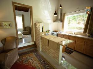 a kitchen with a table and a window in it at Chales Vinhas da Harmonia l Pousada em Cunha SP in Cunha
