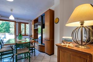 a kitchen and dining room with a table and a lamp at Sardinia Re - Casa Ginestra in Stintino +20 photos