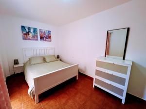 a bedroom with a bed and a dresser and a mirror at Apartamento El Platanal in Tazacorte