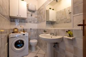 a bathroom with a washing machine and a sink at Sardinia Re - Casa Ginestra in Stintino