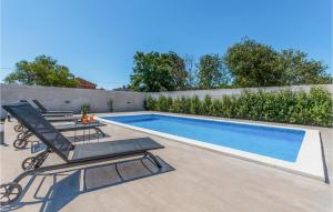 basen z krzesłem i stołem obok niego w obiekcie Cozy Home In Biograd Na Moru w Biogradzie na Moru