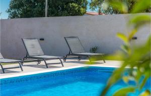 trzy krzesła siedzące obok basenu w obiekcie Cozy Home In Biograd Na Moru w Biogradzie na Moru