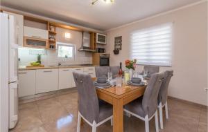 kuchnia i jadalnia z drewnianym stołem i krzesłami w obiekcie Cozy Home In Biograd Na Moru w Biogradzie na Moru