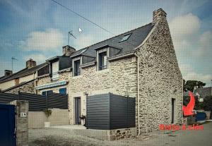 a brick house with a black roof at Studio Saint-Jacques in Sarzeau