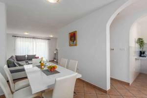 jadalnia i salon z białym stołem i krzesłami w obiekcie Holiday home in Porec/Istrien 10330 w Poreču