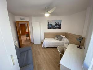 una piccola stanza con un letto e un divano di Piso céntrico reformado a Torredembarra