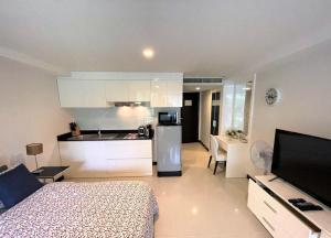 a room with a bed and a kitchen with a refrigerator at Studio at Kris Condo walk to Bangtao beach 2304 in Bang Tao Beach