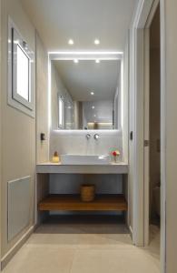 un baño con lavabo y espejo en Lago Beach Living, en Faliraki 40 fotos más