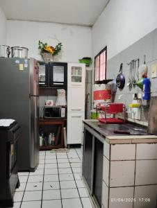 a kitchen with a refrigerator and a tiled floor at Quarto em casa compartilhada in Manaus +16 photos