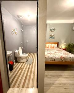 a bathroom with a bed and a toilet in a room at Shanti's Inn in General Luna