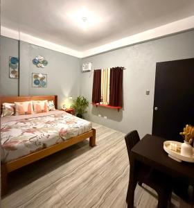 a bedroom with a bed and a desk and a table sidx sidx sidx at Shanti's Inn in General Luna