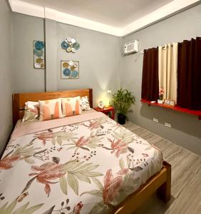 a bedroom with a bed with a floral bedspread at Shanti's Inn in General Luna