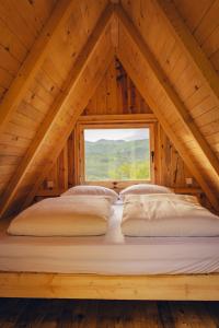 a bed in the attic of a wooden house at Mountain Camp Outdoor Tara in Tjentište