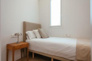 A bed or beds in a room at Newly Renovated Stylish Eixample - Great Location